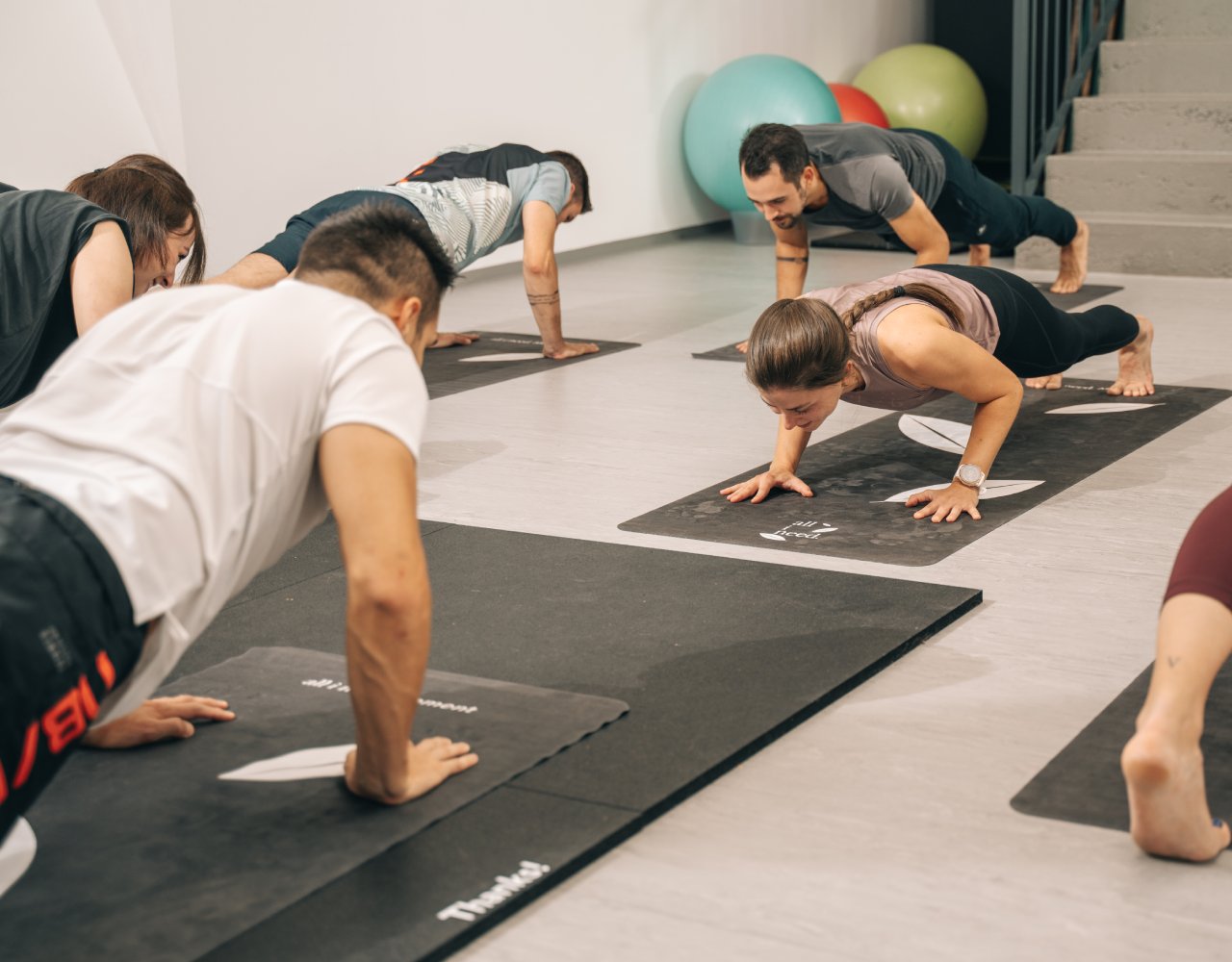 Gruppen-Fitness Training von Trainerin Chrisi mit Teilnehmern bei der Ausführung von Liegestützen