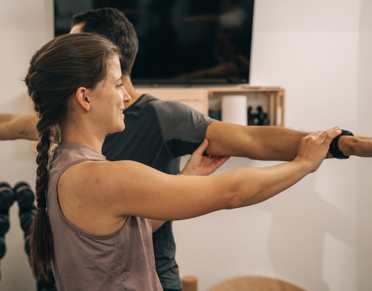 Gruppen-Fitness Training mit Trainerin Chrisi bei der Hands-On Ausführungskontrolle eines Teilnehmers