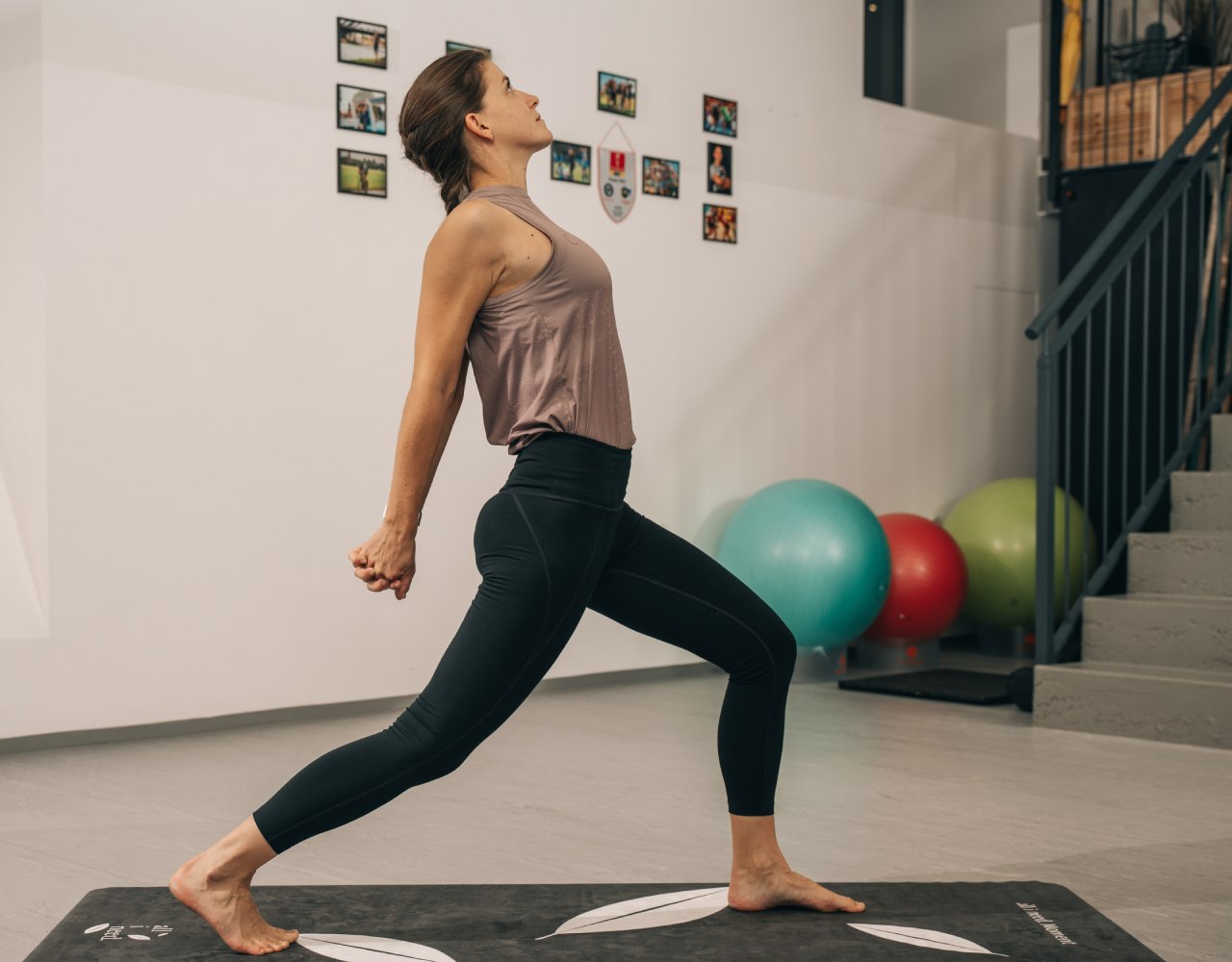 Yoga-Trainerin Chrisi im Krieger mit Blick nach oben, von der Seite zu sehen